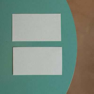 Top view of creative white mock up business cards with copy space placed on round green table in light room