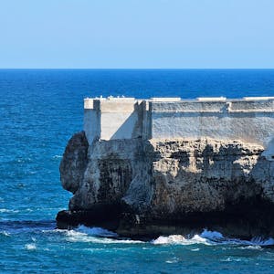 Majestic coastal cliff with deep blue ocean waves, perfect for travel inspiration.